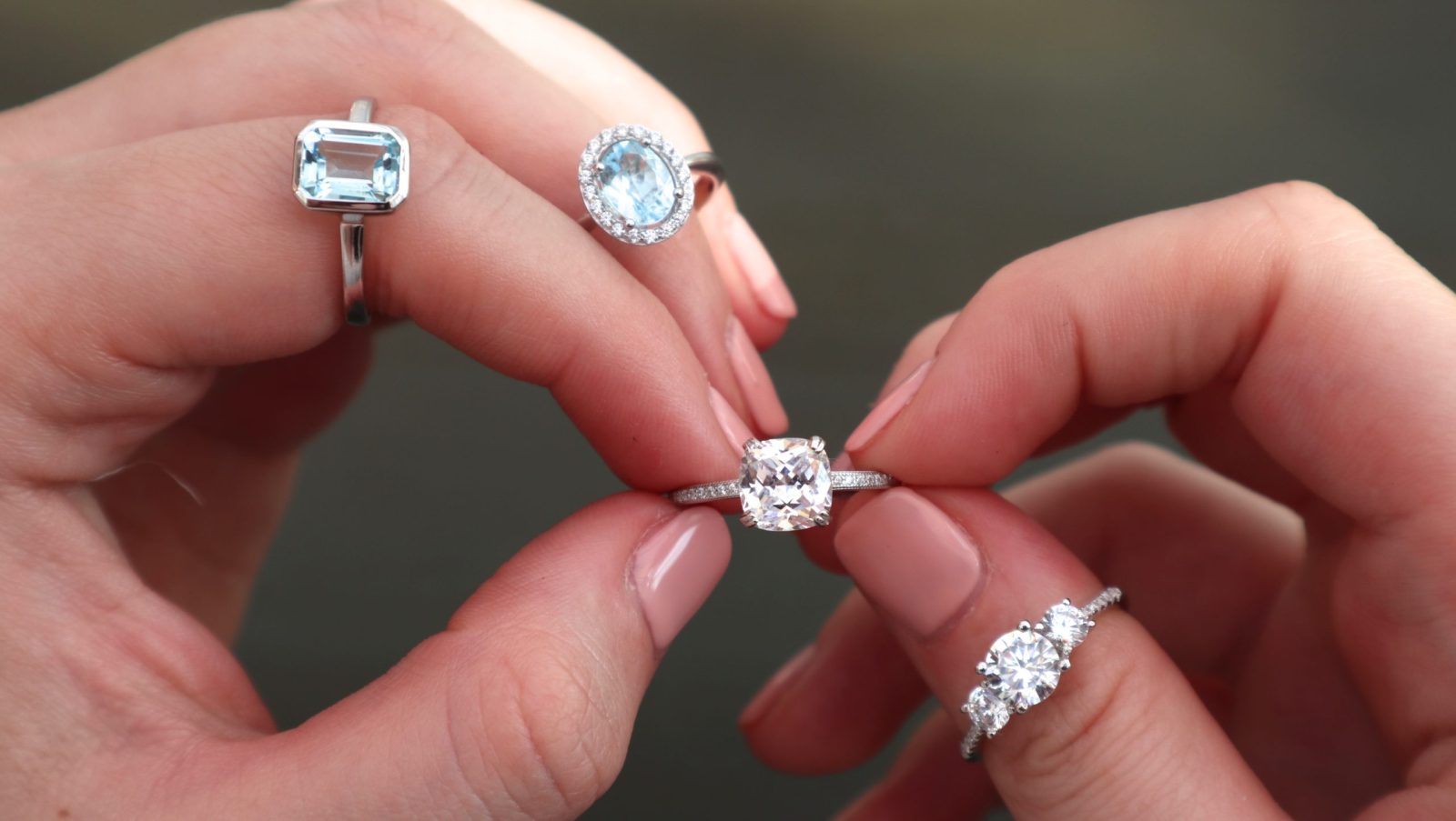 Diamond and aquamarine rings held up to the light