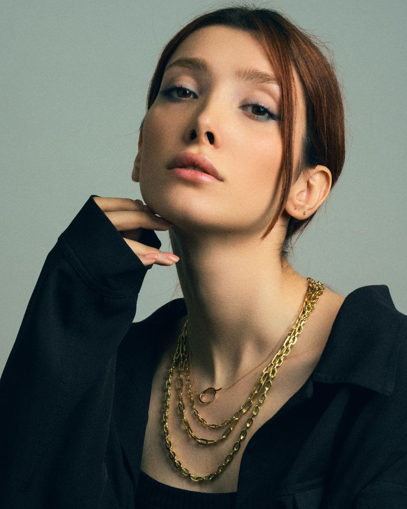 Layered gold chains worn with a black jacket