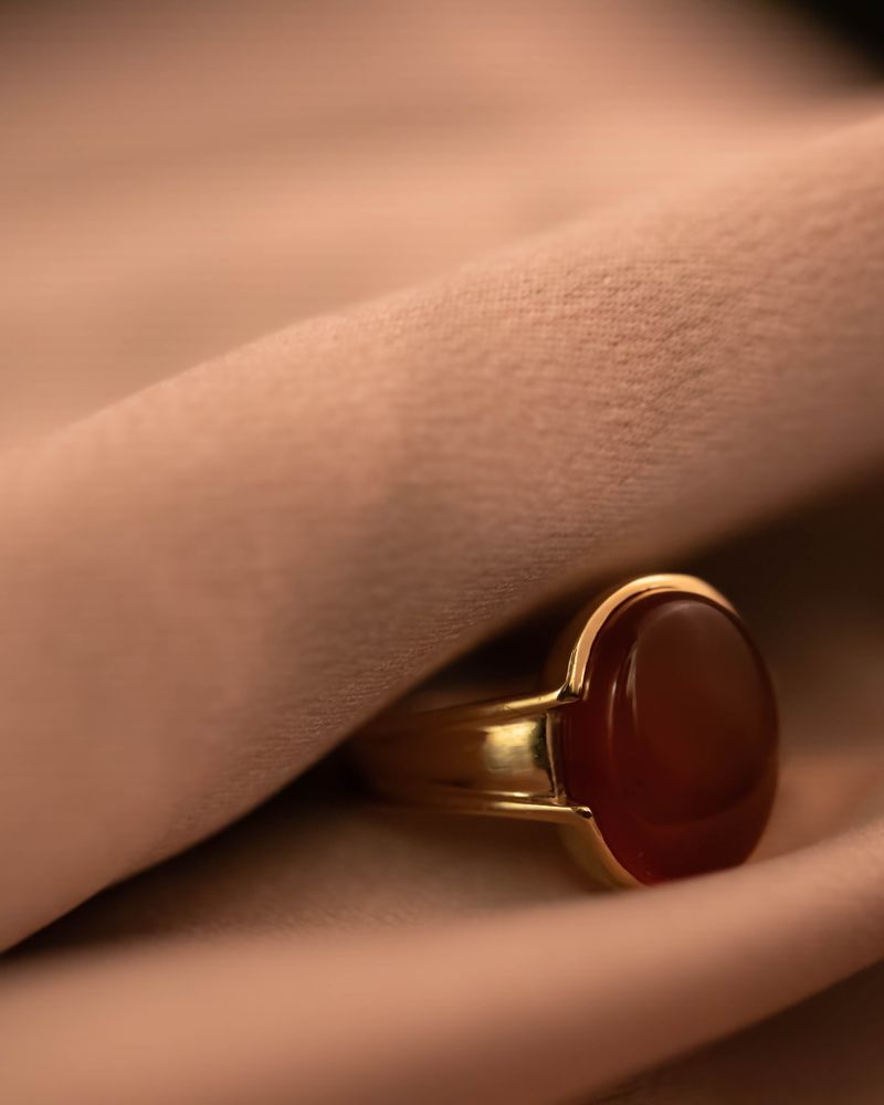 A gold signet ring set with a red stone